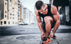 Man tying his shoes in preparation for a run